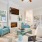 Spacious and well lit living room with wood flooring, large windows and open access to the kitchen