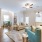 Spacious and well lit living room with wood flooring, large windows and open access to the kitchen