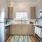 Spacious and well lit kitchen with wood flooring and stainless steel appliances