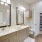 Large well lit bathroom with white accents and a large closet